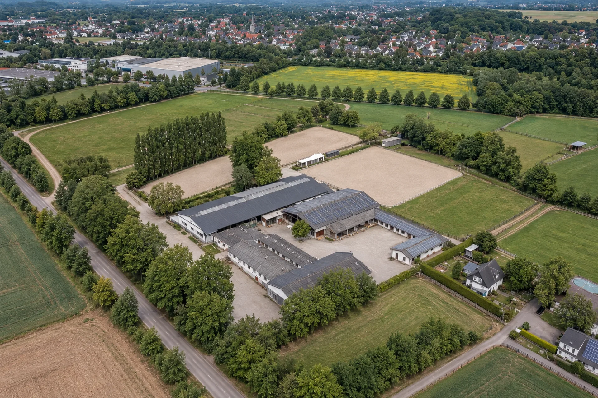 Professionelle Reitanlage mit Stallungen, Reitplätzen und Weiden aus der Luft