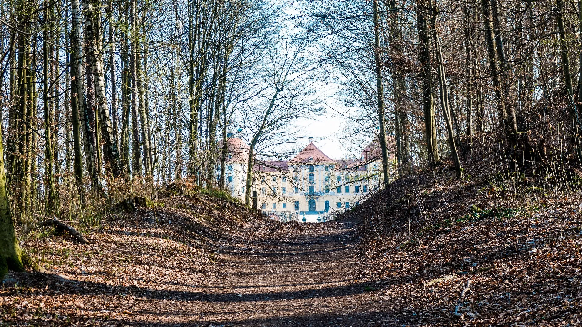 Allee mit Blick auf ein historisches Anwesen